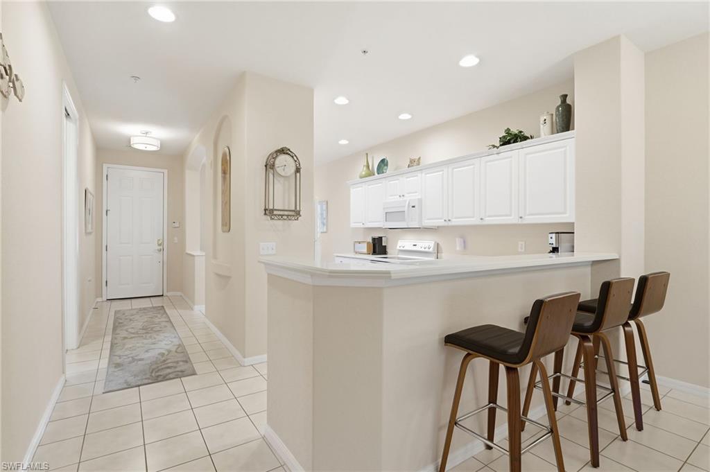 4873 Hampshire Court, Unit 104 Naples, FL 34112 - Photo 10 of 43 a kitchen with a sink cabinets and window