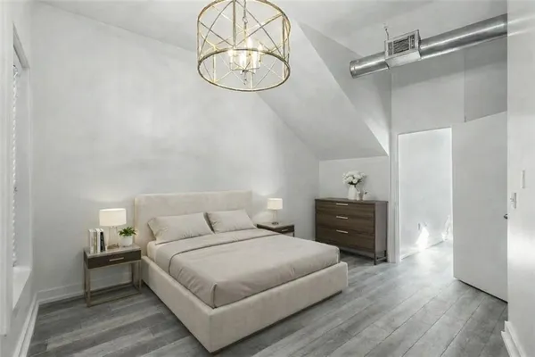 an empty room with wooden floor mirror and windows