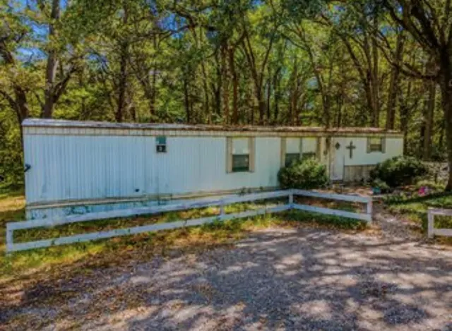 a view of a backyard with plants and small pool