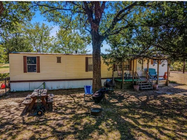 a backyard of a house with table and chairs