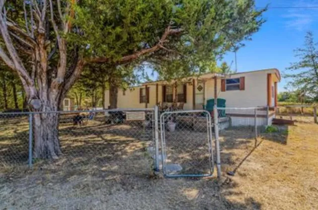 a view of a house with a tree in the yard