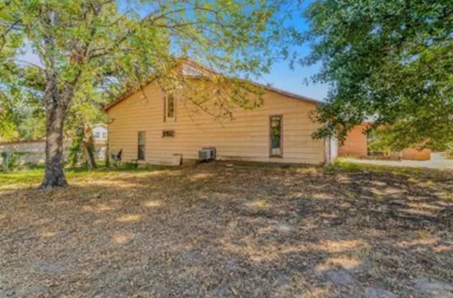 a view of a house with backyard and trees