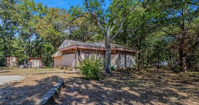 a wooden house with trees in front of it