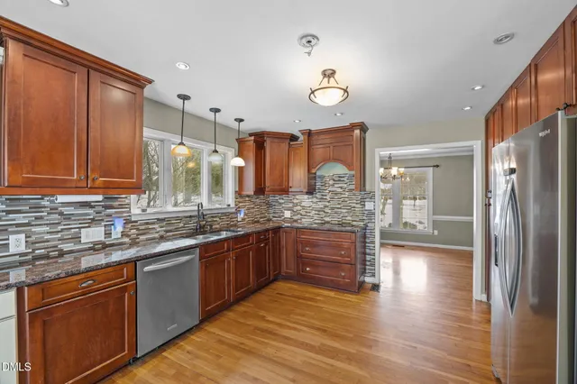a kitchen with granite countertop a stove a sink and a refrigerator