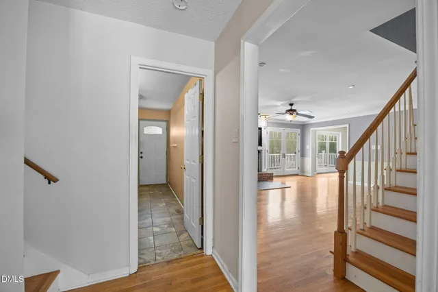 a view of a room with wooden floor and ceiling fan