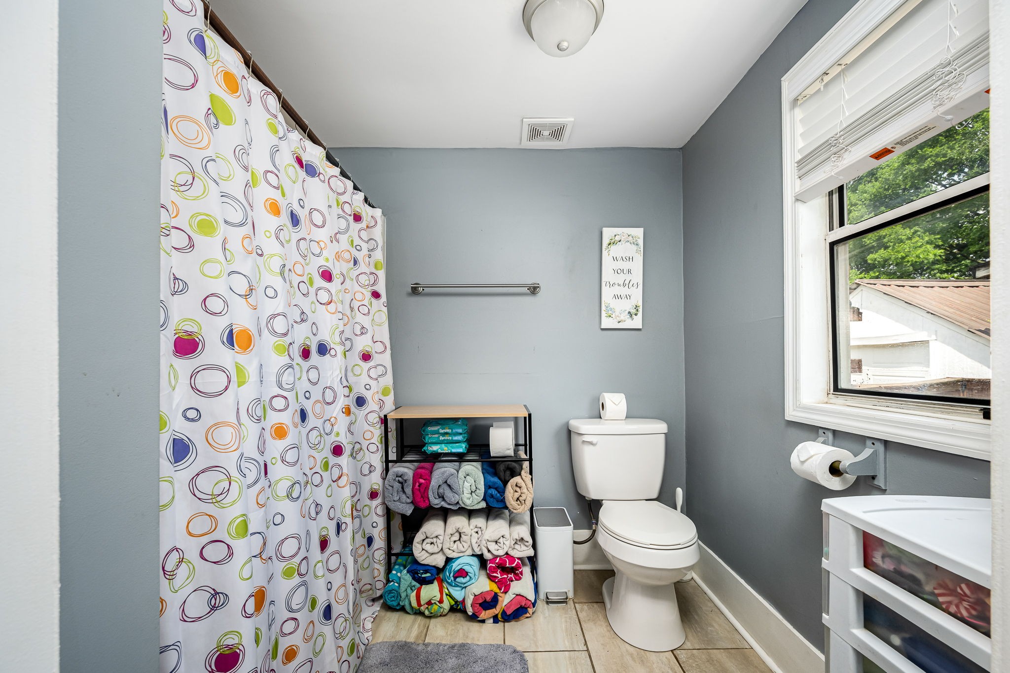 634 Highway 52 Portland, TN 37148 - Photo 21 of 42 a white toilet sitting next to a blue curtain with a curtain and a sink