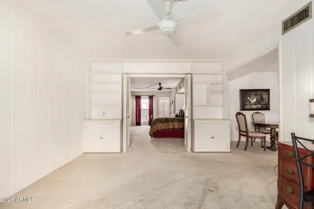 an empty room with closet and windows