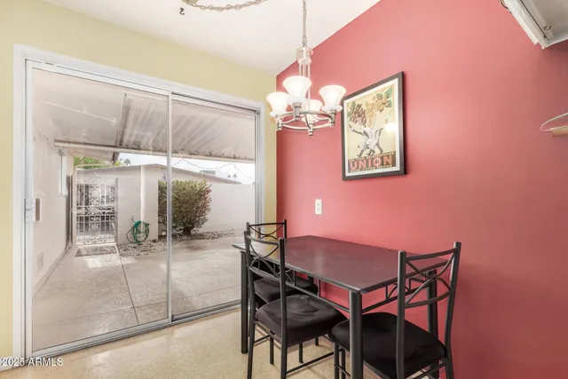 a dining room with chandelier and wooden floor