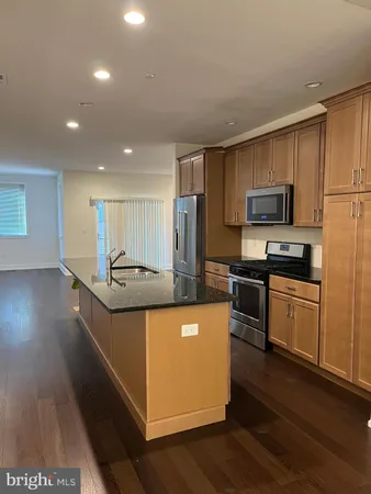 a large kitchen with stainless steel appliances and a refrigerator