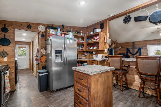 a kitchen with refrigerator and chairs
