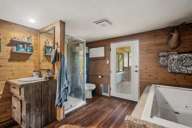 a view of a patio with couches chairs dining table and chairs with wooden floor