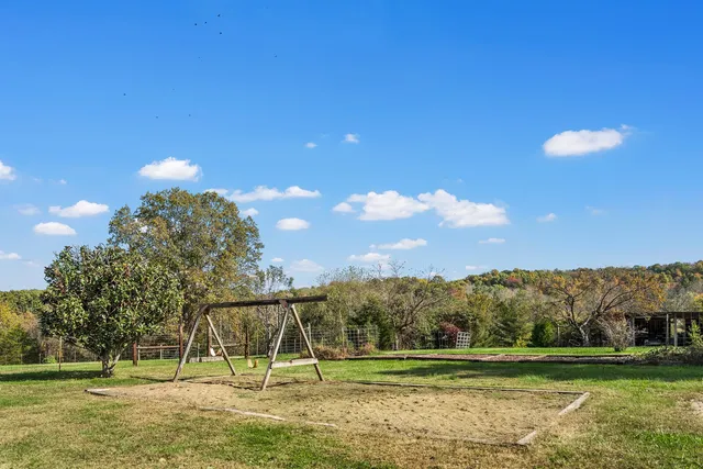 a front view of house with yard and trees in the background