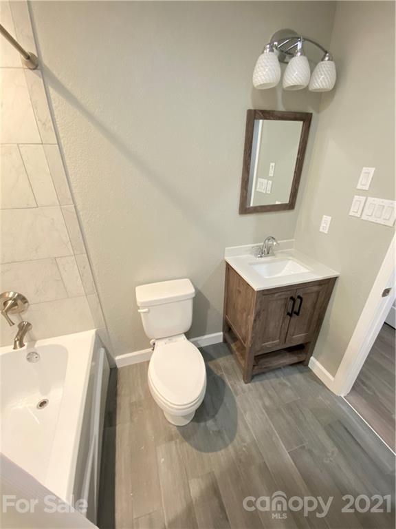 536 Fairview Road Marion, NC 28752 - Photo 11 of 34 a bathroom with a toilet sink a mirror and vanity