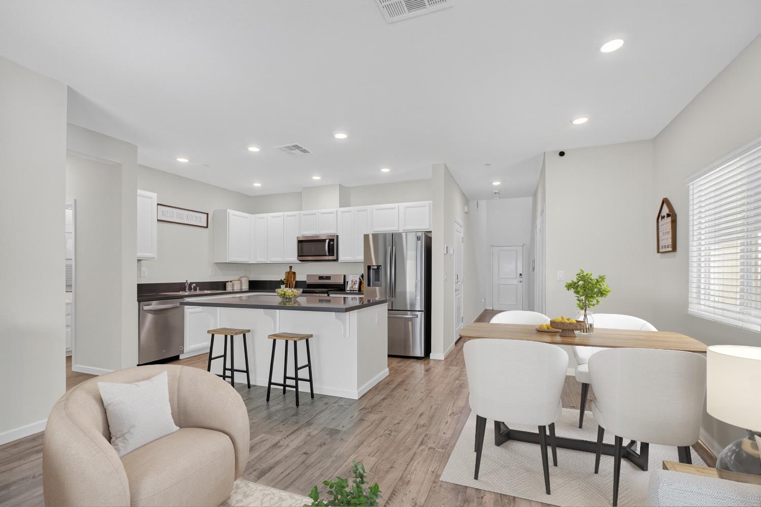 11786 Socrates Way Rancho Cordova, CA 95742 - Photo 4 of 48 a kitchen with kitchen island a dining table chairs stainless steel appliances and cabinets