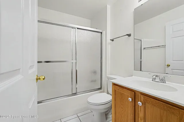 an empty room with a window and a kitchen