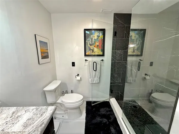 a en suite bathroom with a granite countertop sink and a mirror