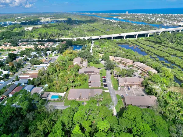 an aerial view of residential houses with outdoor space and trees