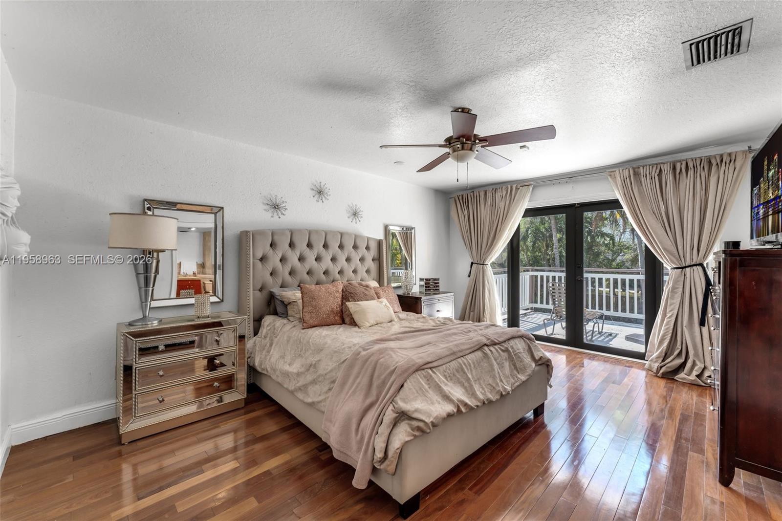 16564 Southwest 153rd Court Miami, FL 33187 - Photo 19 of 45 a bedroom with a bed a couch and a large window with wooden floor