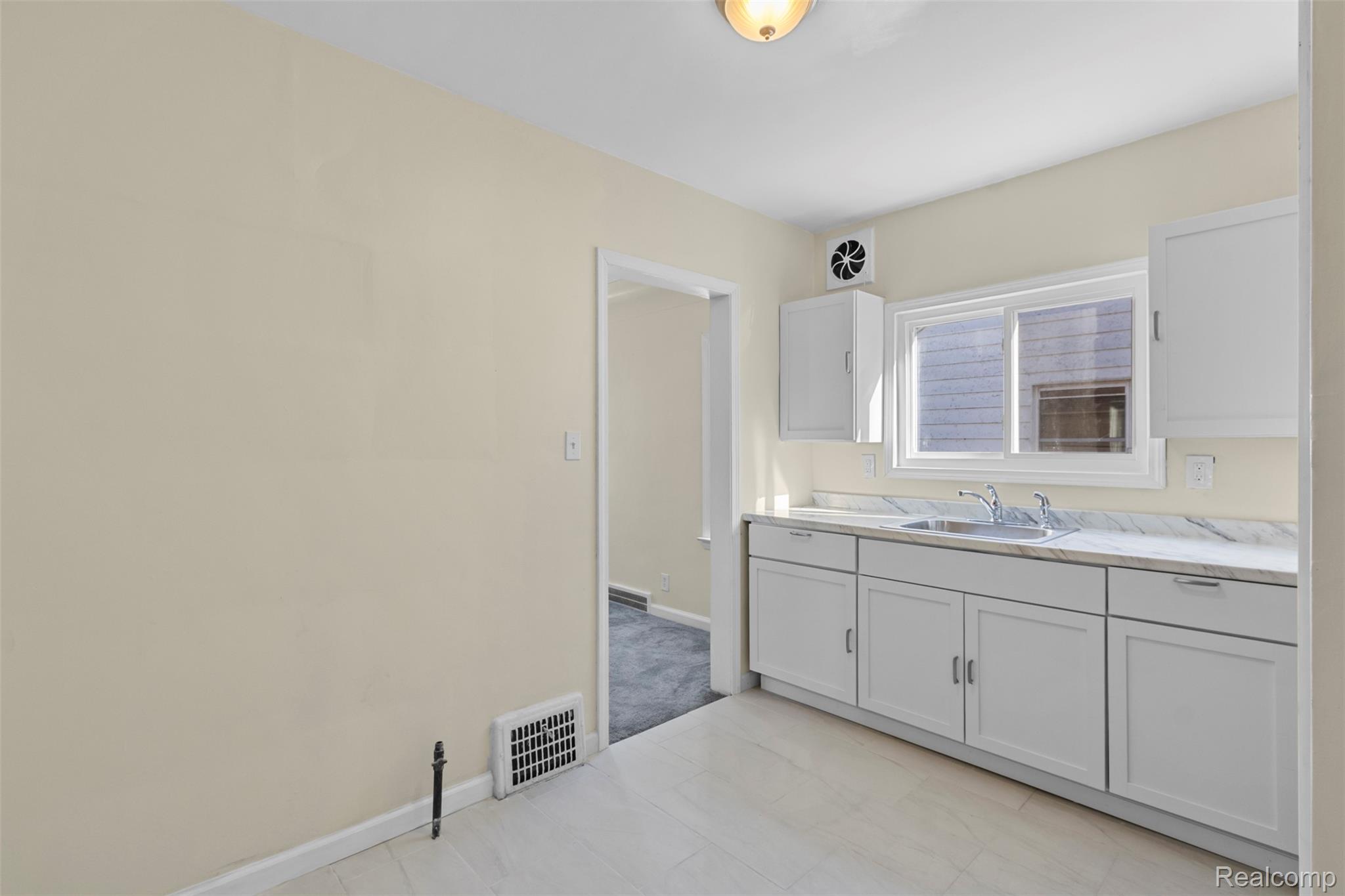 13575 Rutherford Street Detroit, MI 48227 - Photo 11 of 16 Kitchen featuring light countertops and white cabinets