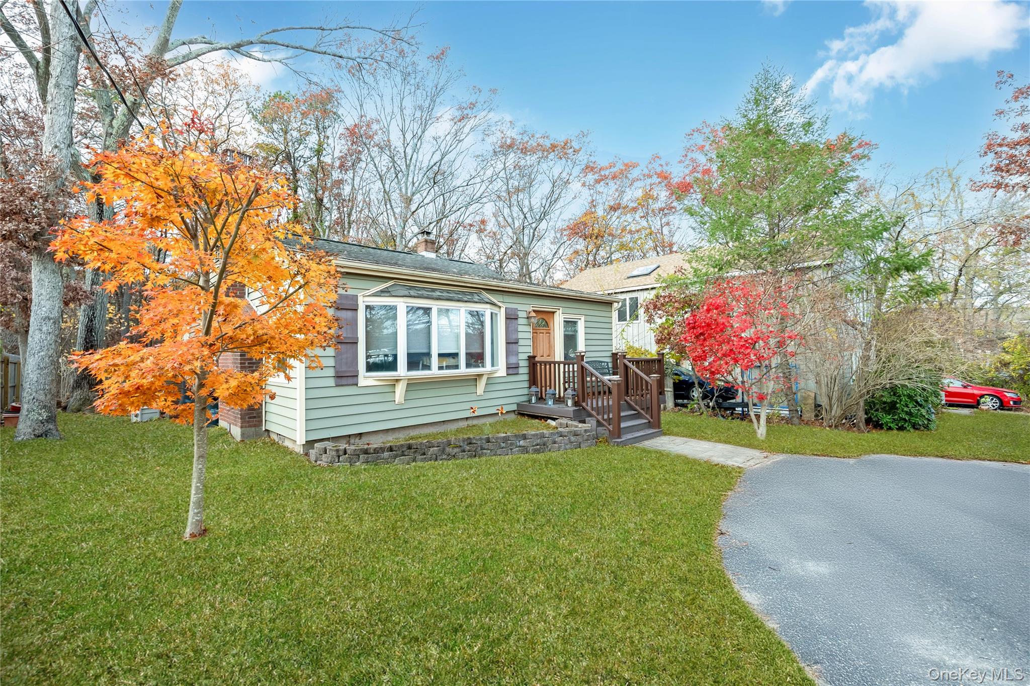 180 Lakeside Trail Ridge, NY 11961 - Photo 2 of 22 a front view of a house with a yard table and chairs