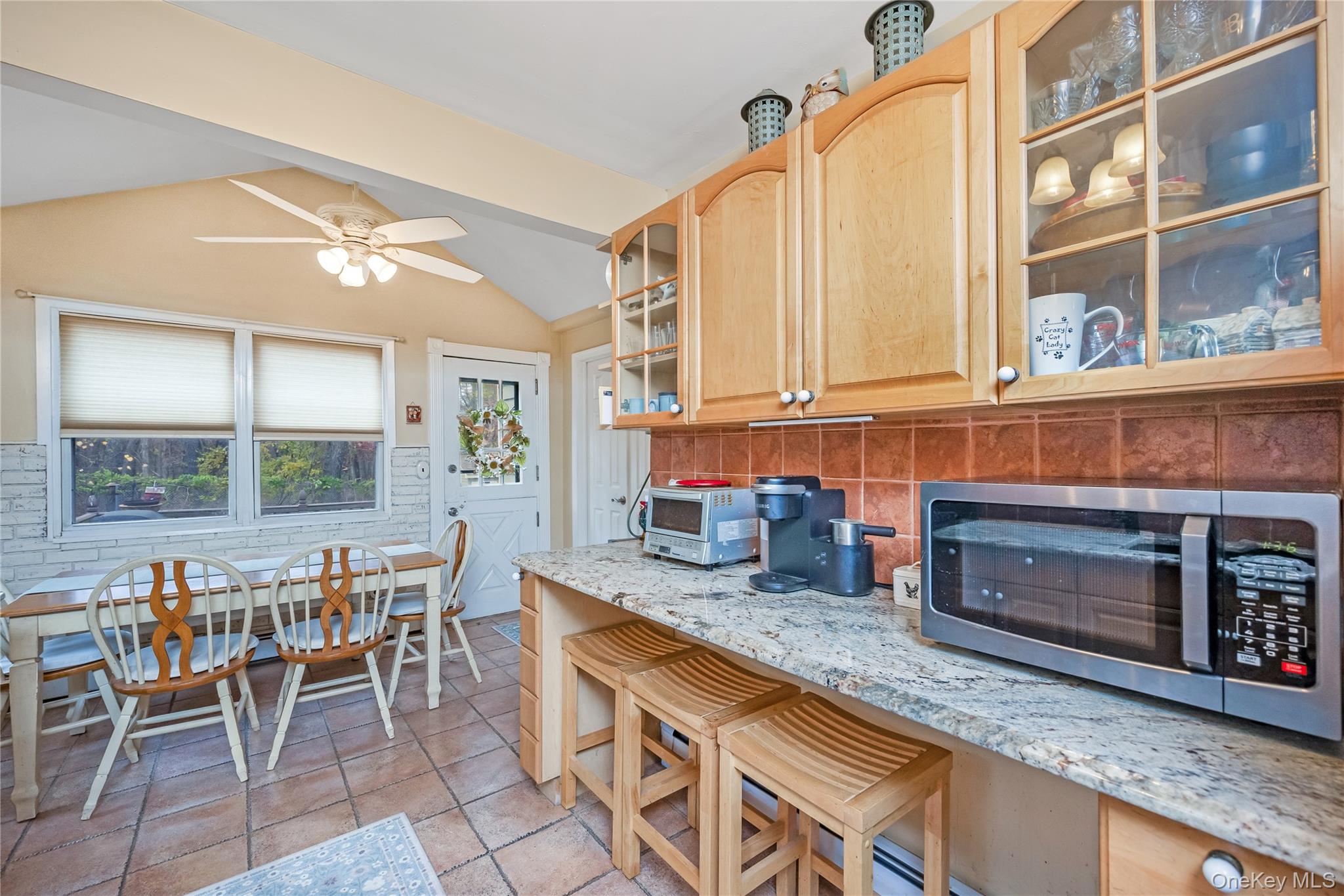 180 Lakeside Trail Ridge, NY 11961 - Photo 6 of 22 a kitchen with granite countertop a stove a sink and a dining table chairs
