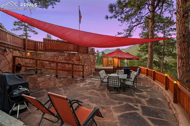 a view of a patio with a table and chairs under an umbrella