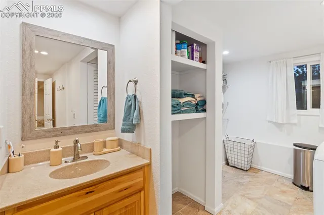 a en suite bathroom with a granite countertop sink and a mirror
