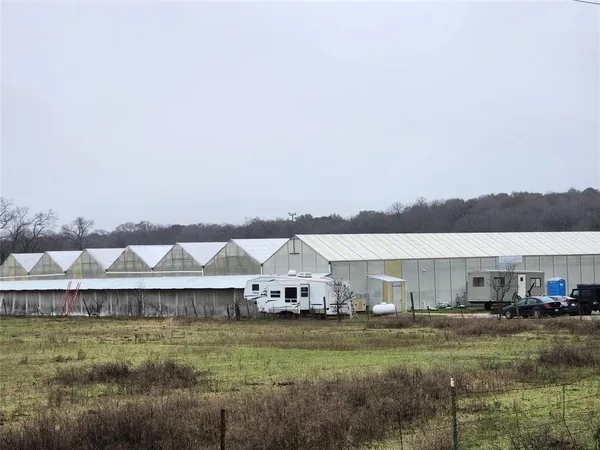 a view of a house with a big yard and large trees