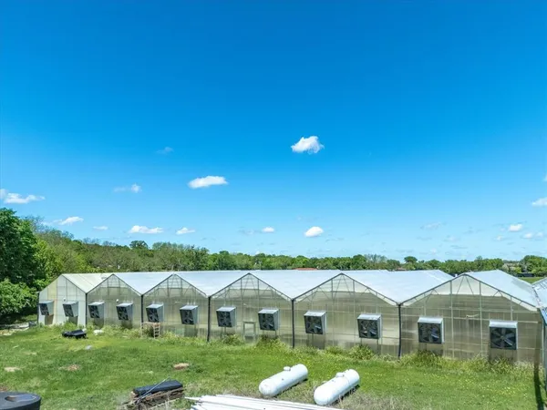 a view of a house with a big yard and potted plants