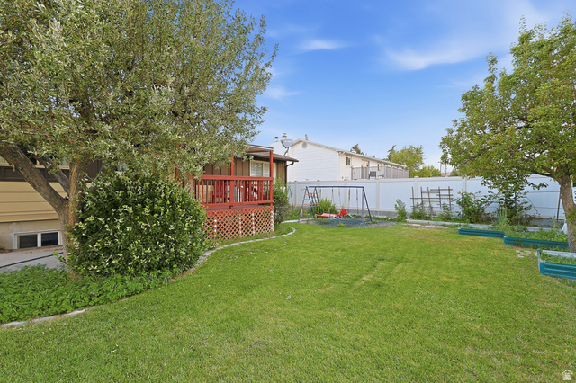 822 Pinewood Circle Price, UT 84501 - Photo 39 of 49 Spacious backyard featuring a manicured lawn, mature trees, and a raised wooden deck with lattice detailing