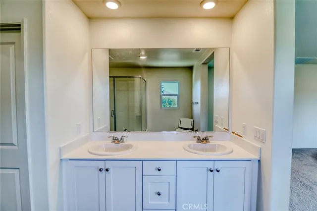 a bathroom with a double vanity sink and a shower