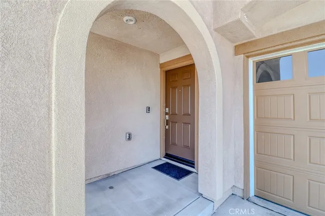 a view of a hallway with wooden floor and a bathroom