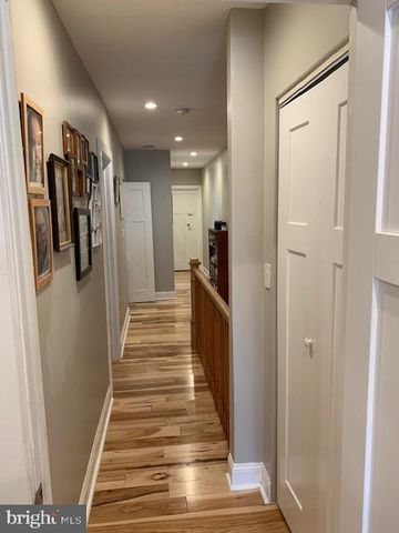 a view of a hallway with wooden floor and stairs