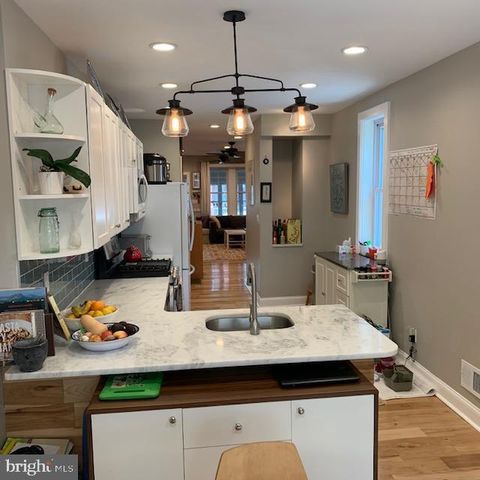 a kitchen with kitchen island granite countertop a sink a counter top space and living room view