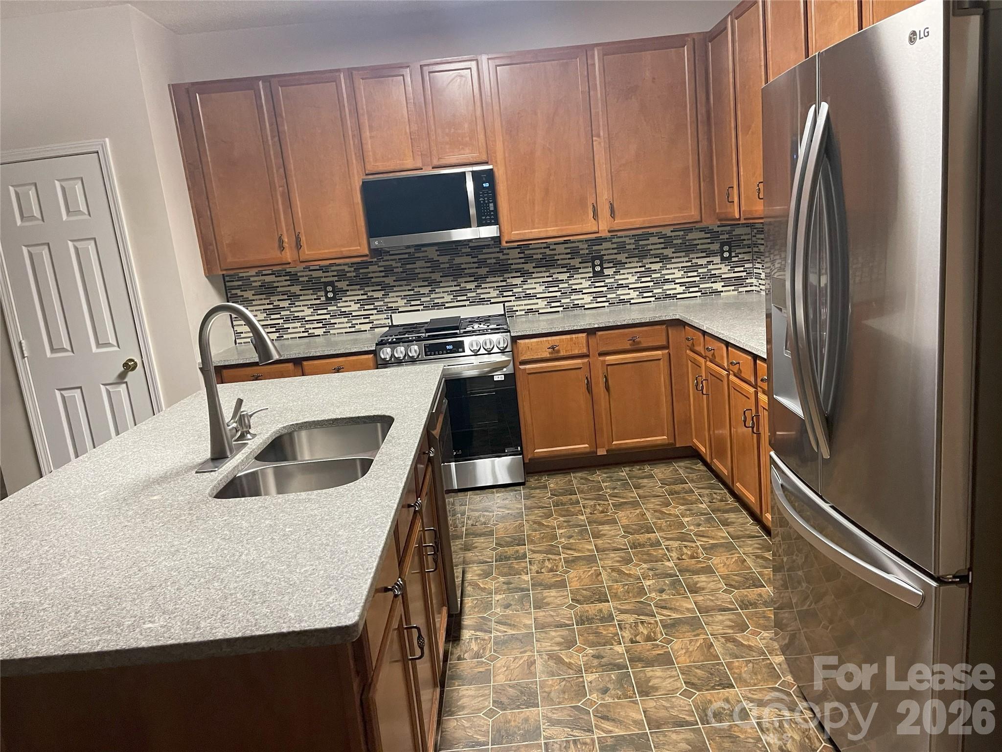 4532 Brookwood Road Charlotte, NC 28215 - Photo 2 of 11 a kitchen with granite countertop a refrigerator a stove a sink and a counter space