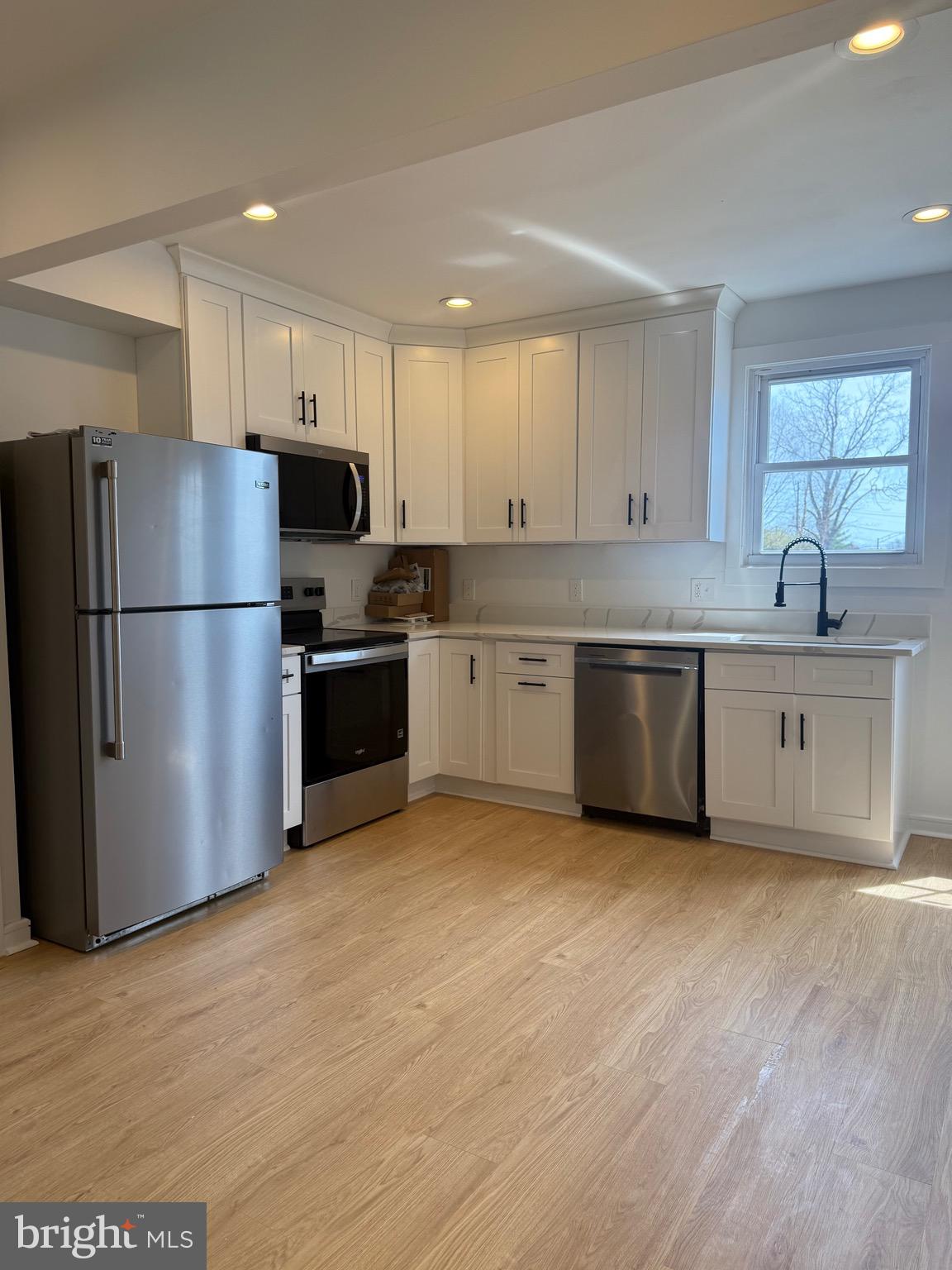 2125 1/2 Oakland Road Baltimore, MD 21220 - Photo 4 of 18 a kitchen with stainless steel appliances a refrigerator sink and microwave