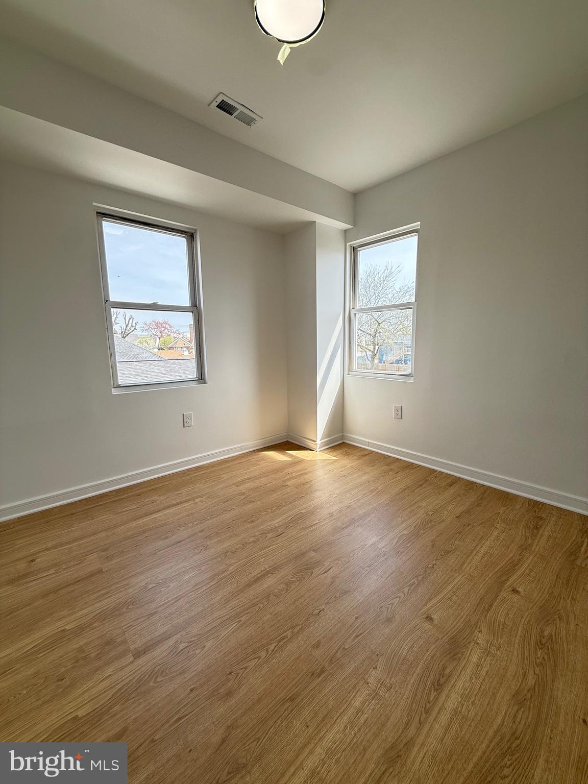 2125 1/2 Oakland Road Baltimore, MD 21220 - Photo 10 of 18 an empty room with wooden floor and windows