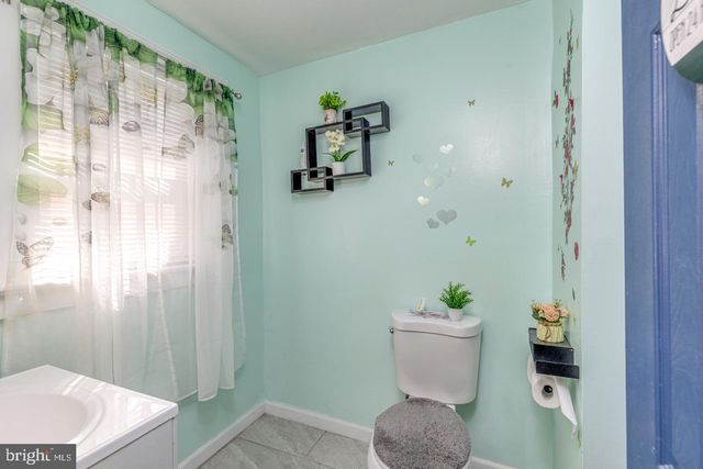 a bathroom with a sink a toilet and shower curtain