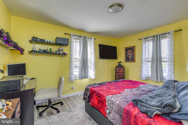a bedroom with a bed table chair and a flat screen tv