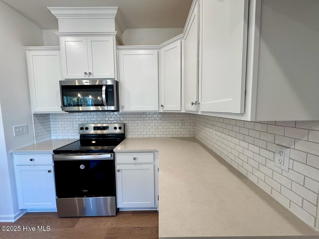 45 Covey Rise Way Lillington, NC 27546 - Photo 12 of 62 HIGHLIGHTS: Silestone Desert Silver Quartz Countertops and Elegant White–2x4 Brick Joint Mosaic Tile Backsplash with Fossil Grout.