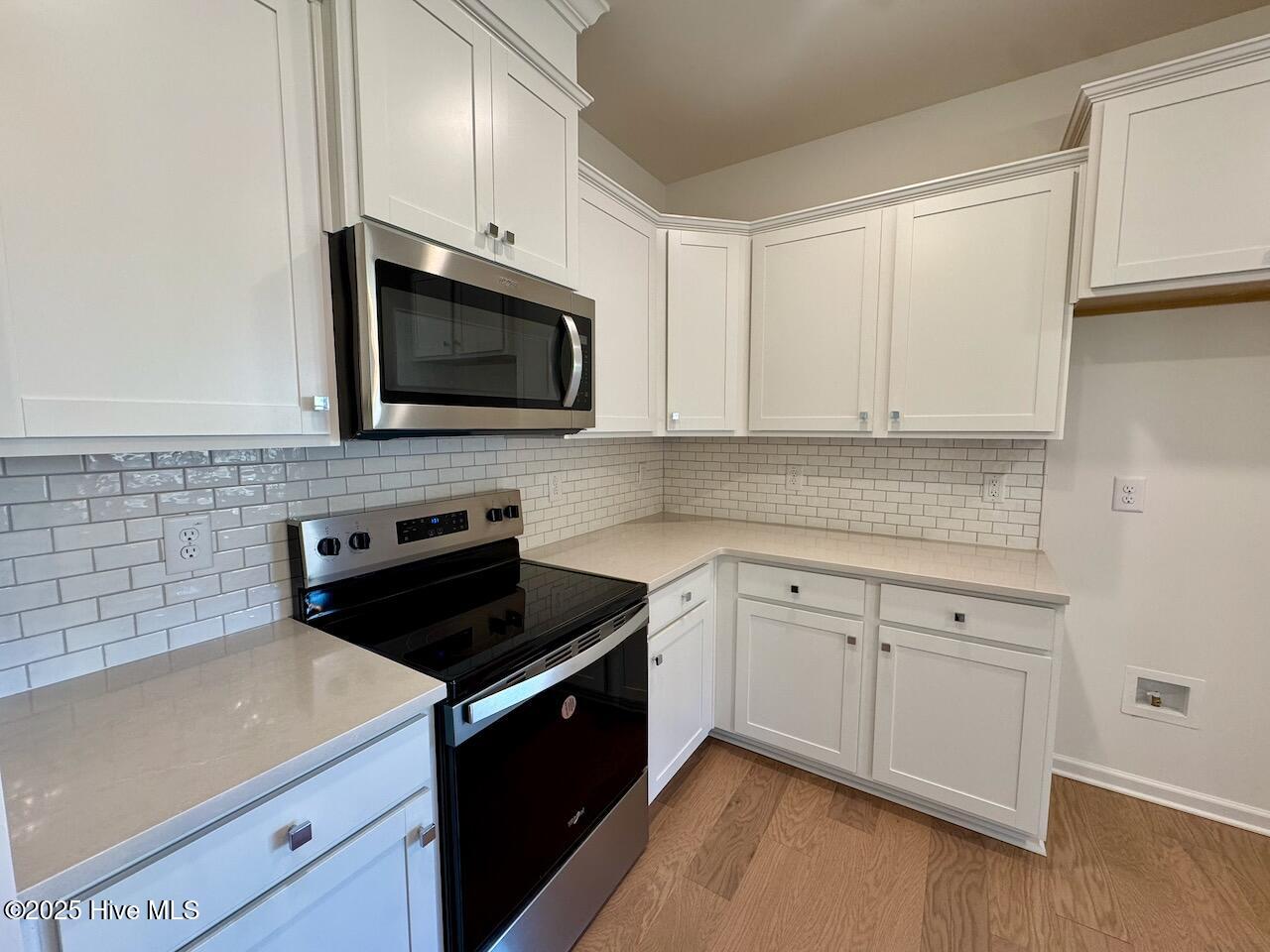 45 Covey Rise Way Lillington, NC 27546 - Photo 13 of 62 HIGHLIGHTS: Silestone Desert Silver Quartz Countertops and Elegant White–2x4 Brick Joint Mosaic Tile Backsplash with Fossil Grout.