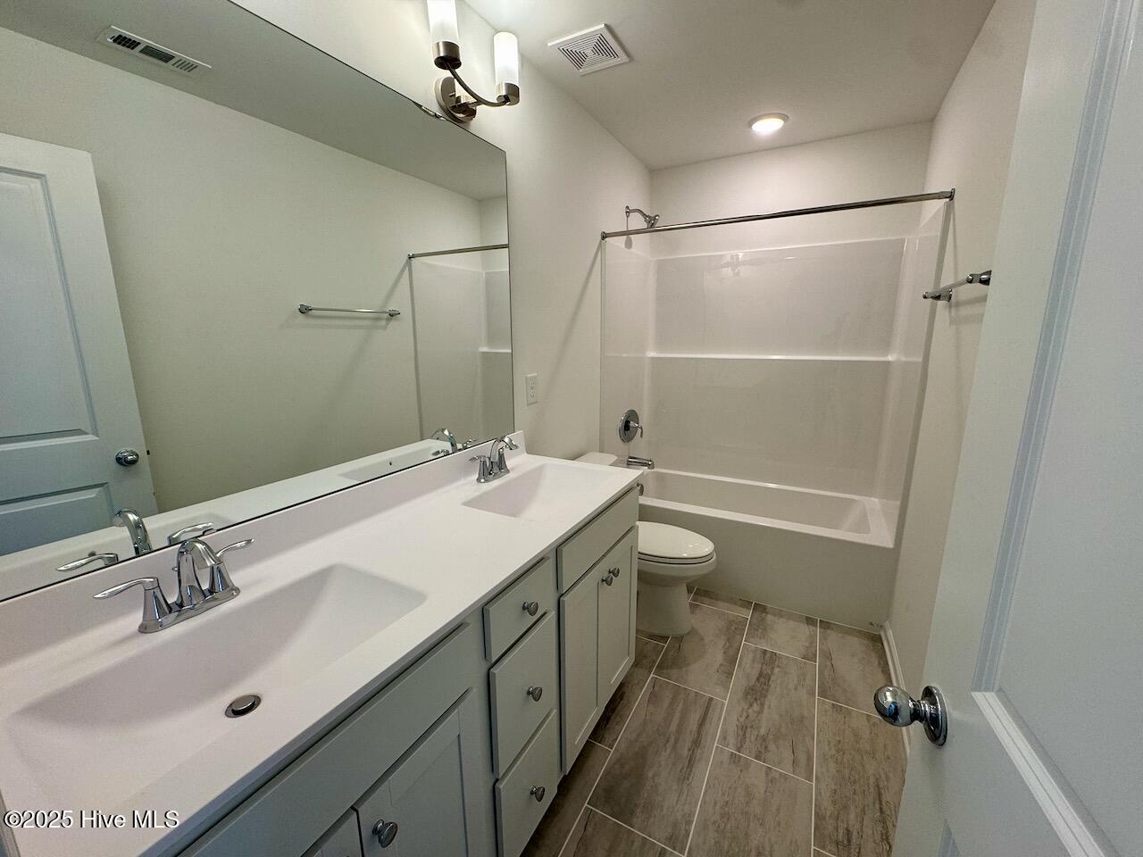 45 Covey Rise Way Lillington, NC 27546 - Photo 47 of 62 HIGHLIGHTS: Costar Mount Claire Ash-Rectangle 1/2 Staggered Brick Pattern Tile Floor, Double Vanity with a Frameless Mirror, Upgraded Polish Nickel Lights, Faucet, and Cabinet Hardware, Disk Lighting, and a Combo Shower/Tub.