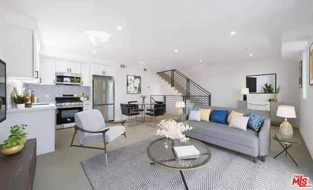 a living room with furniture kitchen view and a table