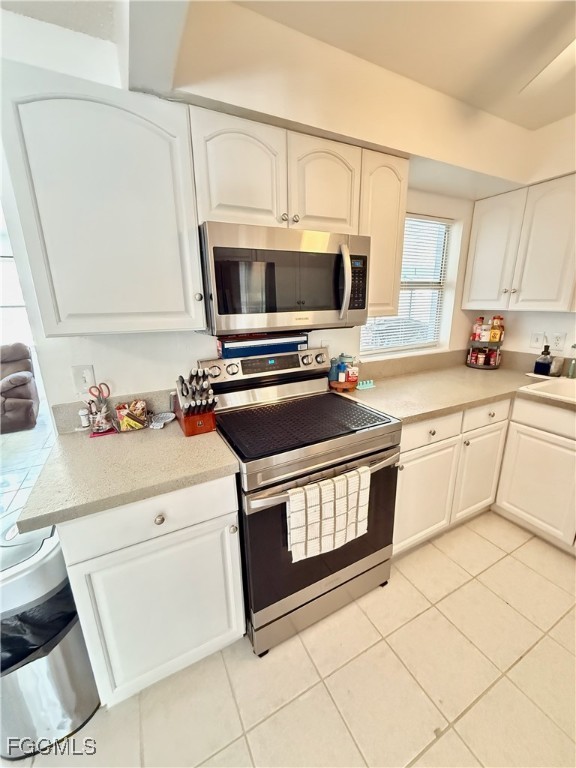 314 Vermont Way Lehigh Acres, FL 33936 - Photo 12 of 45 a kitchen with a stove a sink and a microwave