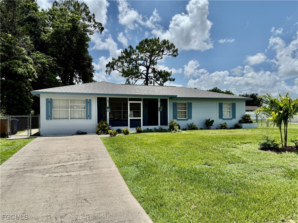 314 Vermont Way Lehigh Acres, FL 33936 - Photo 3 of 45 a front view of a house with a garden and porch