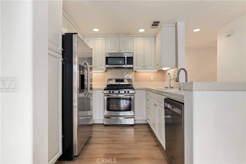 28364 Mirabelle Lane Saugus, CA 91350 - Photo 6 of 32 a kitchen with kitchen island granite countertop a stove and a refrigerator