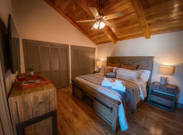 a bedroom with a bed and a flat screen tv