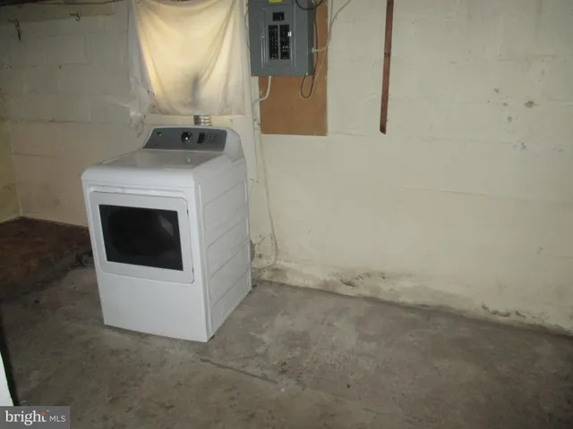 a view of a white house with a small yard and large tree