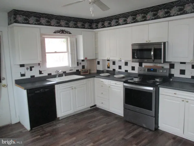 a kitchen with white cabinets stainless steel appliances and sink