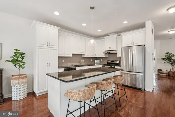 a living room with furniture and a view of kitchen
